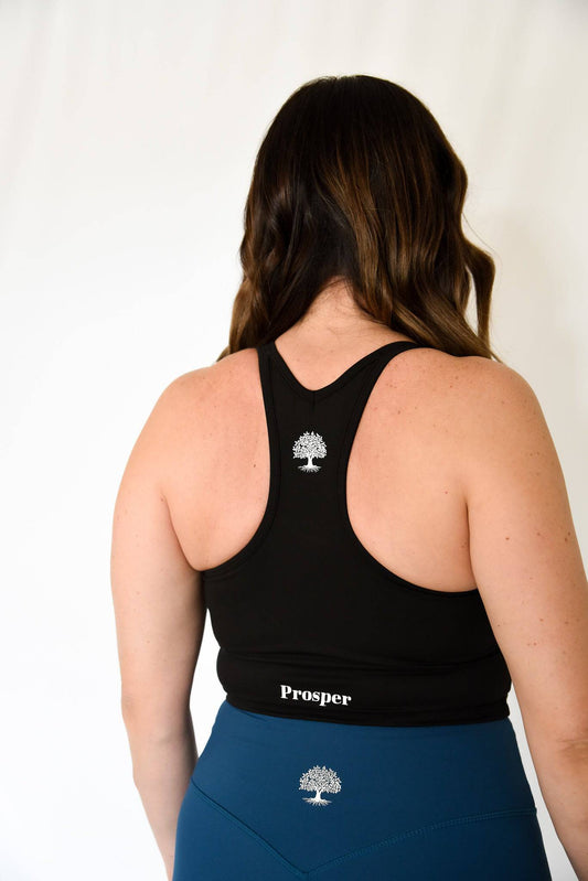 Anthem Sports Bra from back view in black with Prosper tree logo located between shoulder blades on the racer back and Prosper written on the lower back