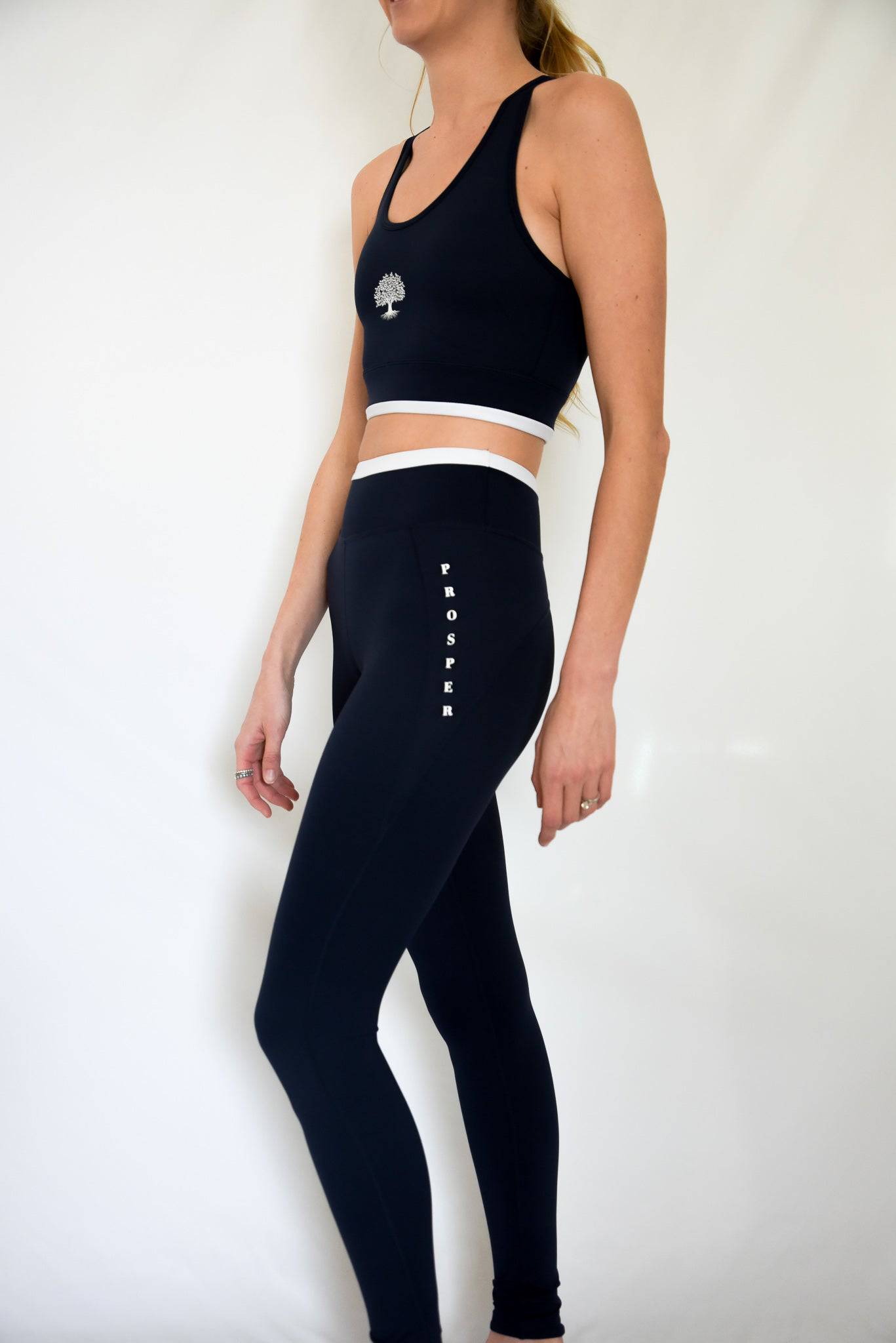 Contender Leggings from Left Side in Navy showing "Prosper" logo written vertically on left hip