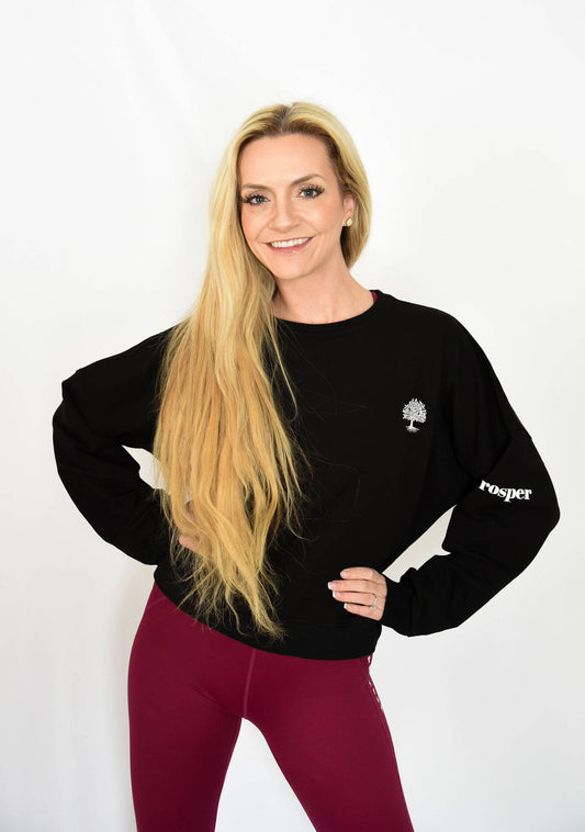Cotton Dream Sweatshirt in Black front view showing Tree logo and "Prosper" on left arm sleeve paired with Cranberry Contender Leggings