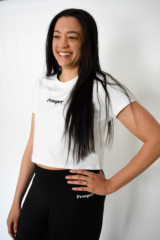 The Best Mother's Day Gifts for the Mom Who Never Skips a Workout - Image of Woman smiling with white Prosper Tee and black Everyday Leggings on